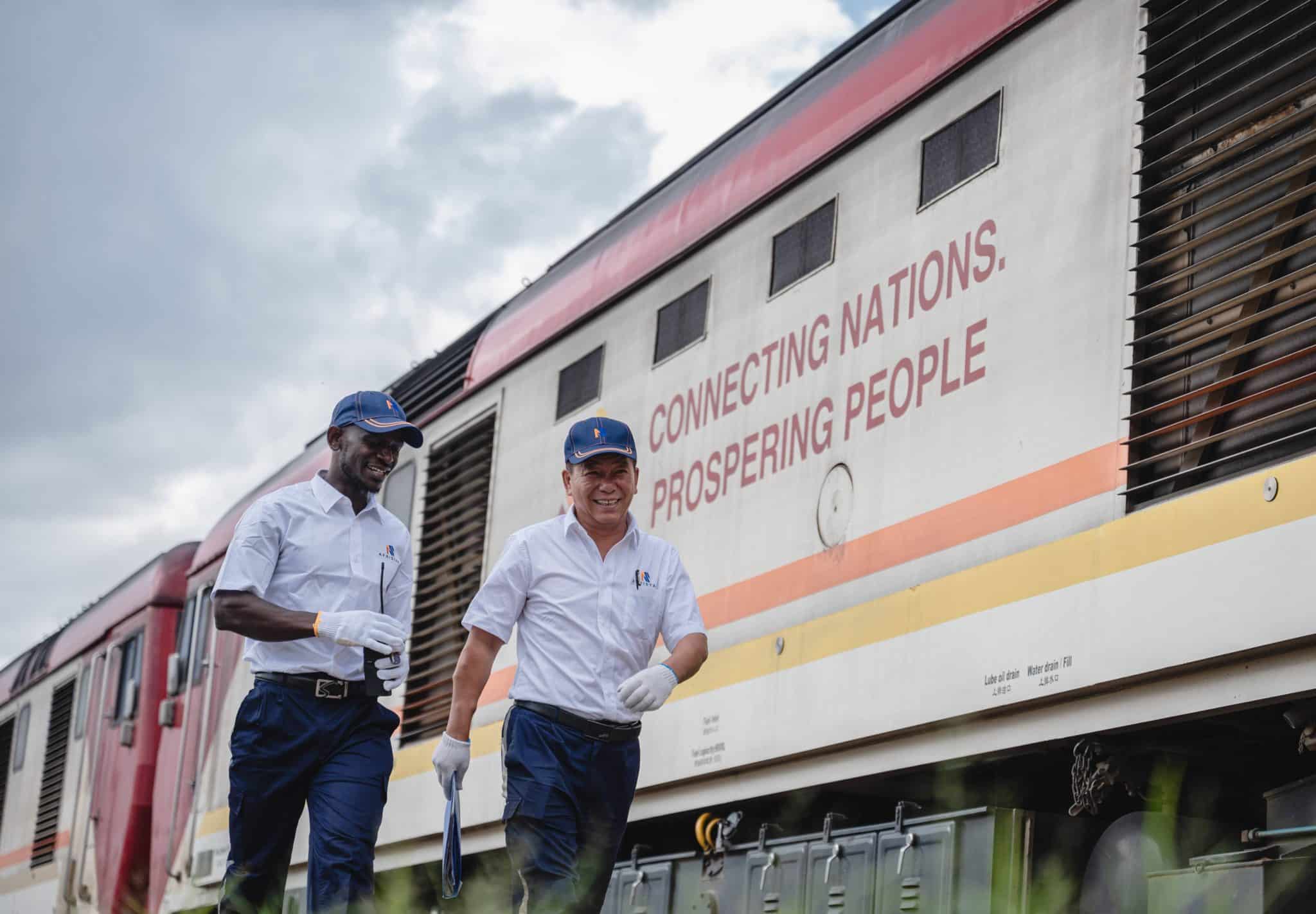 Chinese instructor Jiang Liping (R) and apprentice Horace Owiti walk past a train carriage on the Mombasa-Nairobi Railway, which has become a flagship project of China-Africa cooperation, a "business card" of Chinese enterprises and a demonstration project of the Belt and Road Initiative.